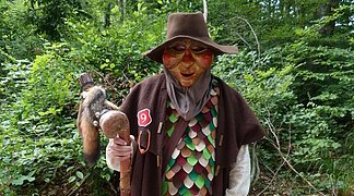 Die Wemdinger Sagengestalt "Huaderle" steht mit einem braunen Gewand im Wald.