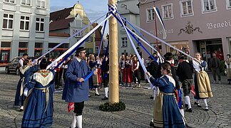 Der Trachtenverein tanzt um den Maibaum.