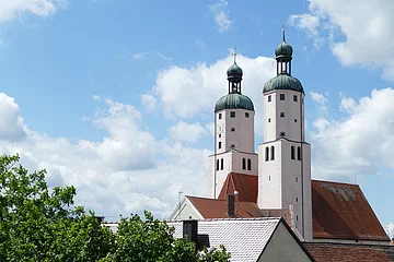 Blick auf die Türme der Stadtpfarrkirche mit weiß blauem Himmel