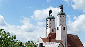 Blick auf die Türme der Stadtpfarrkirche mit weiß blauem Himmel