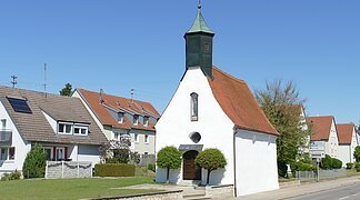Die Leonhardkapelle vom Straßenrand aus an einen sonnigen Tag.