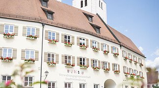 Zwei Radfahrer fahren am Verwaltungsgebäude mit ihrem Fahrrad vorbei.