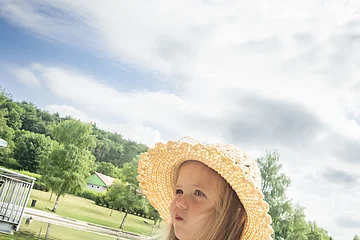Ein Kind isst Pommes am Waldsee.