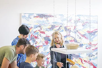 Eine Familie macht eine Führung im KunstMuseum und sieht sich bestimmte Gesteine an.