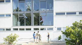 Die Leiterin des KunstMuseums zeigt das Museum von außen und führt es einer Gruppe vor.
