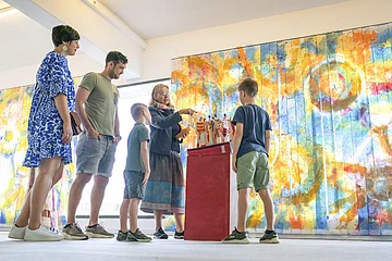 Eine Familie sieht sich im KunstMuseum ein Kunstwerk an.