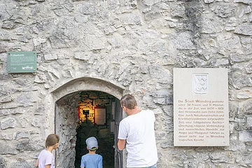 Vater betrachtet den Eingang des Folterturms mit seinen zwei Kindern.
