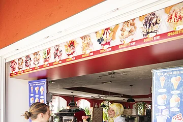 Zwei Mädchen kaufen sich ein Eis an der Eistheke bei Da Francesco.