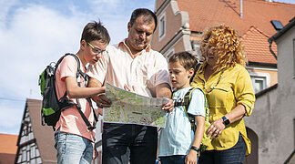Eine Familie betrachtet einen Stadtplan von Wemding.
