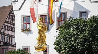 Goldene Marienstatue mit Blick auf das historische Rathaus.