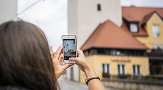 Eine Frau macht ein Foto vom Fuchsturm.