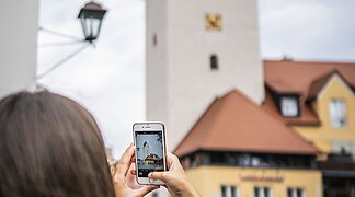 Eine Frau macht ein Foto vom Fuchsturm.
