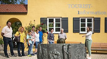 Stadtführerin zeigt ihrer Gruppe den Mangoldbrunnen während einer Stadtführung.