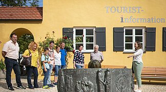 Stadtführerin zeigt ihrer Gruppe den Mangoldbrunnen während einer Stadtführung.