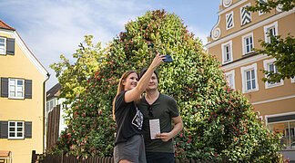 Ein Paar macht ein Selfie vor der Fuchsienpyramide.