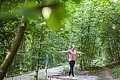 Eine Frau balanciert auf einem Hindernis auf dem Trimm-Dich-Pfad.