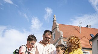 Eine Familie betrachtet einen Stadtplan von Wemding.