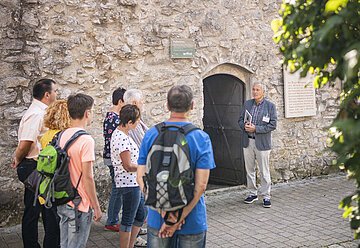 Ein Stadtführer stellt den Folterturm während einer Stadtführung einer Gruppe vor.