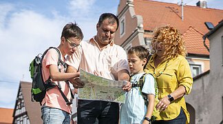Eine Familie betrachtet einen Stadtplan von Wemding.