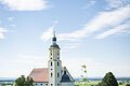 Sommerlicher Blick auf die Wallfahrtsbasilika Maria Brünnlein mit einer blühenden Wiese im Vordergrund.