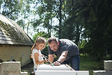 Ein Vater spielt mit seinem Kind Minigolf beim Hotel Gut Wildbad.