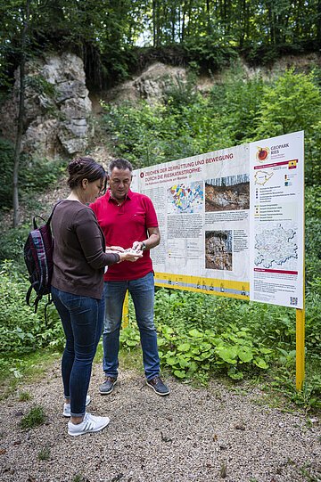 Sagenweg Steinbruch Ein Paar steht vor einer Informationstafel im Steinbruch.