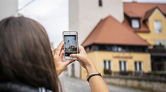 Eine Frau macht ein Foto vom Fuchsturm.