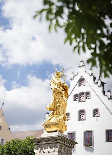 Marienbrunnen am historischen Marktplatz Die goldene Marien Statue vom Marienbrunnen am historischen Marktplatz ist im Vordergrund des Fotos.