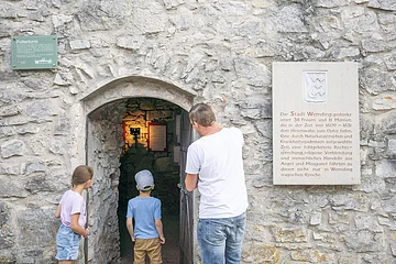 Vater betrachtet den Eingang des Folterturms mit seinen zwei Kindern.