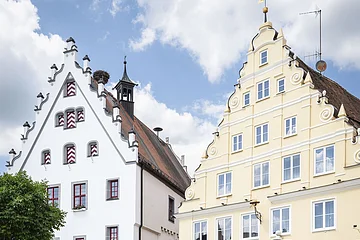 Zwei Radfahrer fahren am historischen Rathaus vorbei.