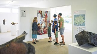 Eine Familie betrachtet ein gemaltes Bild im KunstMuseum Donau-Ries.