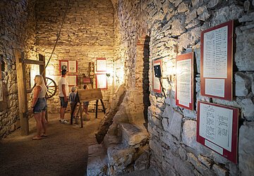 Eine Familie informiert sich im Folterturm Wemding im Rahmen einer Stadtführung mit Besichtigung Folterturm.