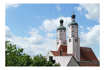 Blick auf die Türme der Stadtpfarrkirche mit weiß blauem Himmel