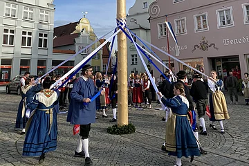 Der Trachtenverein tanzt um den Maibaum.