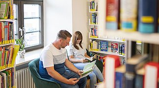 Ein Paar ließt Bücher in der Stadtbücherei.