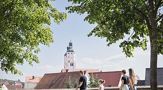 Stadtgraben Wemding Eine Familie mit Hund geht entlang der Stadtmauer spazieren.
