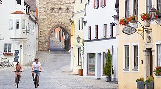 Radfahren in der historischen Altstadt Zwei Radfahrer fahren von der Wallfahrtstraße vom Amerbacher Tor Richtung historischen Marktplatz.